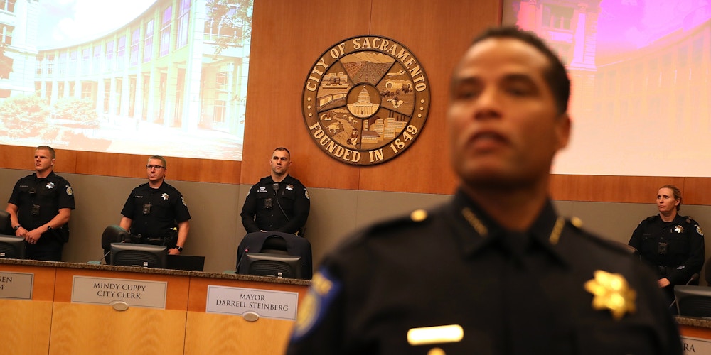 SACRAMENTO, CA - MARCH 27:  Sacramento police officer stand guard inside the council chambers after Stevante Clark, brother of Stephon Clark, disrupted a special city council meeting at Sacramento City Hall on March 27, 2018 in Sacramento, California. Hundreds packed a special city council meeting at Sacramento City Hall to address concerns over the shooting death of Stephon Clark by Sacramento police.  (Photo by Justin Sullivan/Getty Images)