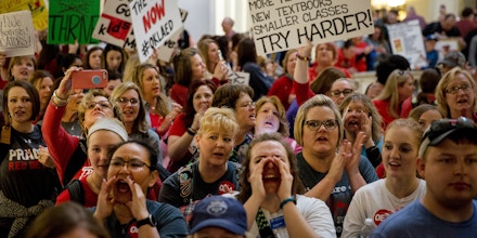 Teachers and demonstrators hold signs during a rally inside the Oklahoma State Capitol building in Oklahoma City, Oklahoma, U.S., on Tuesday, April 3, 2018. Hundreds of teachers crowded into the Oklahoma Capitol for a second day Tuesday to press demands for additional funding for the state's public schools. Photographer: Scott Heins/Bloomberg via Getty Images