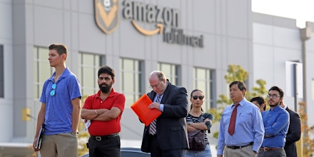 FILE - In this Wednesday, Aug. 2, 2017, file photo, applicants wait in line to enter a job fair at an Amazon fulfillment center, in Kent, Wash. Amazon has narrowed its search for a second headquarters city to 20 locations, concentrated mostly in the East and the Midwest. (AP Photo/Elaine Thompson, File)