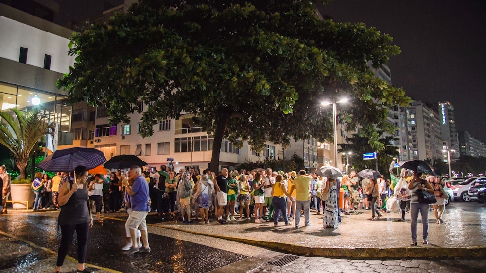 Manifestantes anti-Lula se abrigam embaixo de uma árvore em Copacabana