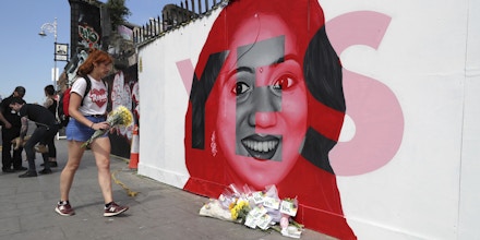 A woman lays flowers next to a mural of Savita Halappanavar in Dublin, as Ireland goes to the polls to vote in the referendum on the 8th Amendment of the Irish Constitution. PRESS ASSOCIATION Photo. Picture date: Friday May 25, 2018. See PA story IRISH Abortion. Photo credit should read: Niall Carson/PA Wire
