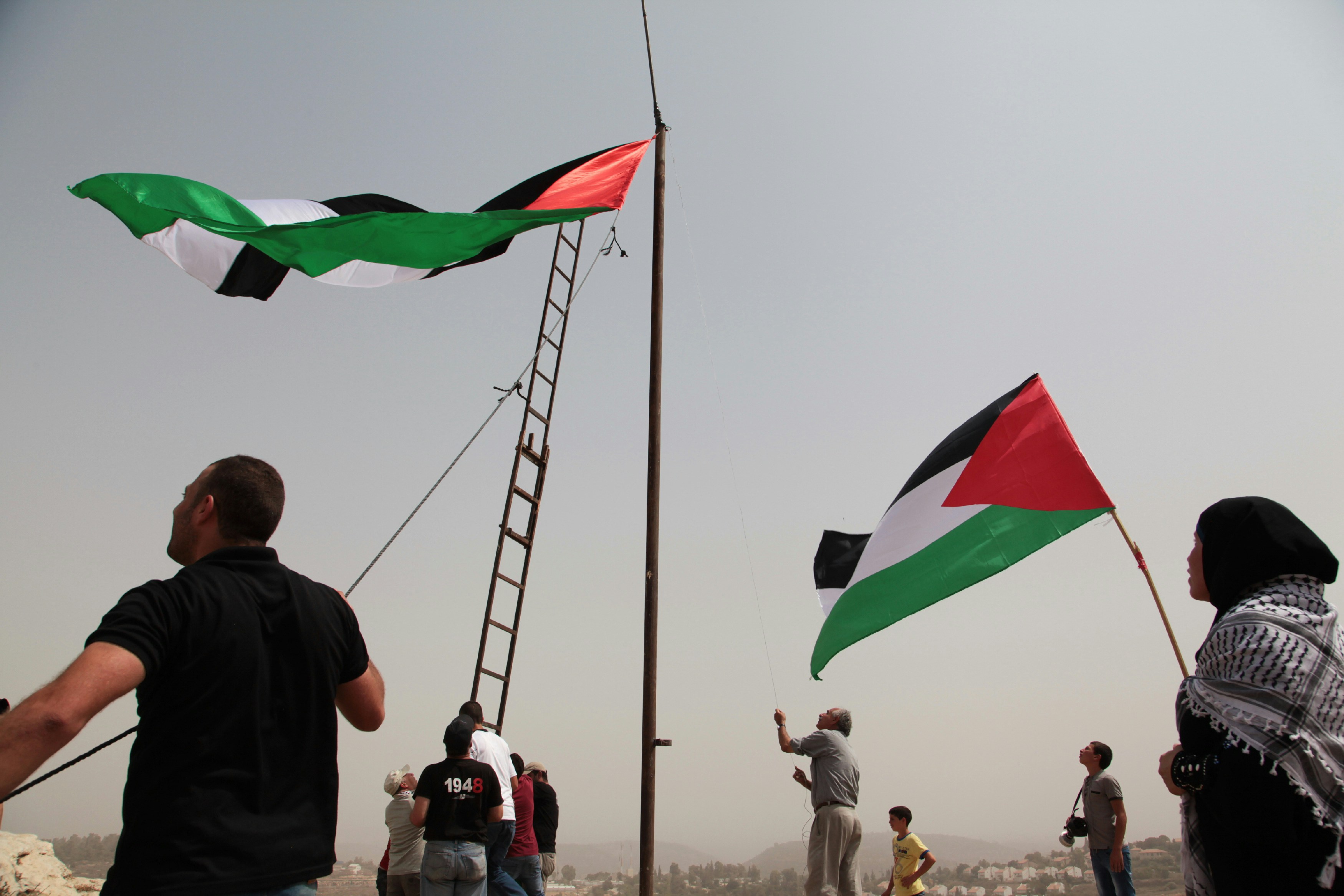Palestinian protesters are raising a huge Palestine flag on flagpole in An Nabi Saleh on Sep 11, 2015. (Photo by Mohammad Alhaj/NurPhoto) (Photo by NurPhoto/NurPhoto via Getty Images)
