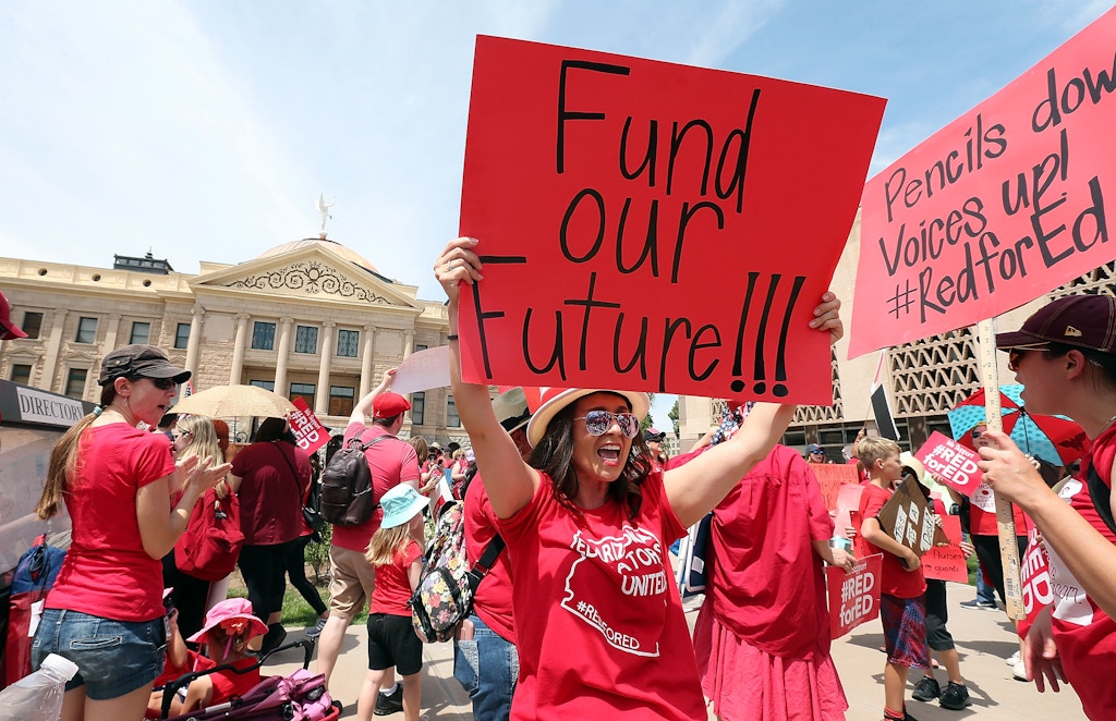 PHOENIX, AZ - APRIL 26:  An Arizona teacher holds up a sign in front of the State Capitol during a #REDforED rally on April 26, 2018 in Phoenix, Arizona. Teachers state-wide staged a walkout strike on Thursday in support of better wages and state funding for public schools.  (Photo by Ralph Freso/Getty Images)