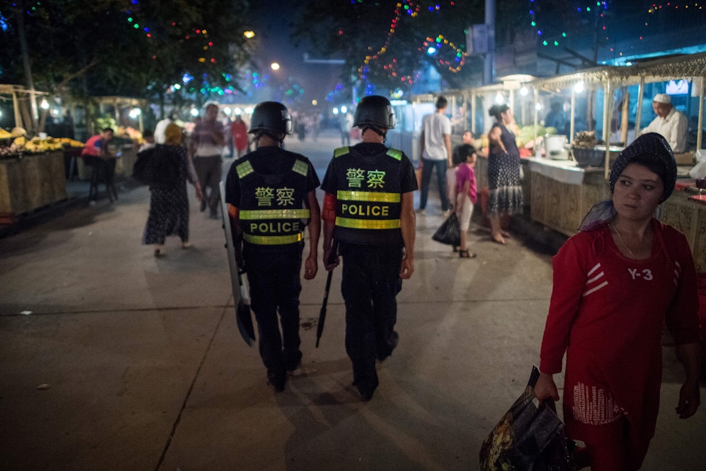 This picture taken on June 25, 2017 shows police patrolling in a night food market near the Id Kah Mosque in Kashgar in China's Xinjiang Uighur Autonomous Region, a day before the Eid al-Fitr holiday.The increasingly strict curbs imposed on the mostly Muslim Uighur population have stifled life in the tense Xinjiang region, where beards are partially banned and no one is allowed to pray in public. Beijing says the restrictions and heavy police presence seek to control the spread of Islamic extremism and separatist movements, but analysts warn that Xinjiang is becoming an open air prison. / AFP PHOTO / Johannes EISELE / TO GO WITH China-religion-politics, FOCUS by Ben Dooley (Photo credit should read JOHANNES EISELE/AFP/Getty Images)
