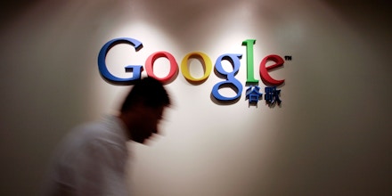 CHINA - AUGUST 15:  A member of Google Inc.'s China staff walks past the Google logo at their office in Shanghai on Wednesday, Aug. 15, 2007. When Thailand blocked Google Inc.'s YouTube Web site last year, the company dispatched deputy general counsel Nicole Wong to help restore access. In Bangkok, a sea of yellow shirts stunned her.  (Photo by Kevin Lee/Bloomberg via Getty Images)