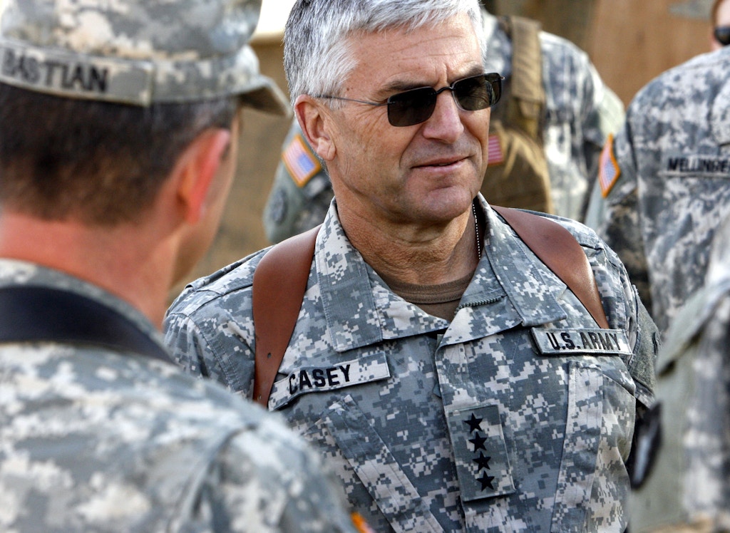 O general do Exército dos EUA George W. Casey Jr, comandante da Força Multinacional do Iraque, conversa com o Major do Exército Sean Bastian, chefe de uma equipe de transição militar, durante uma visita no Dia de Ação de Graças em 23 de novembro de 2006, na Base de Combate Rawah na província de Al Anbar, no Iraque. 