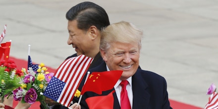 U.S. President Donald Trump, right, and Chinese President Xi Jinping are greeted by children waving flowers and flags during a welcome ceremony at the Great Hall of the People in Beijing, Thursday, Nov. 9, 2017. (AP Photo/Andy Wong)