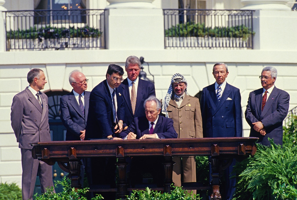 Minister of Foreign Affairs of Israel Shimon Peres puts his signature on the agreement during the signing ceremony of the Oslo 1 Accord, on the South Lawn of the White House on Sept. 13, 1993 in Washington, D.C.