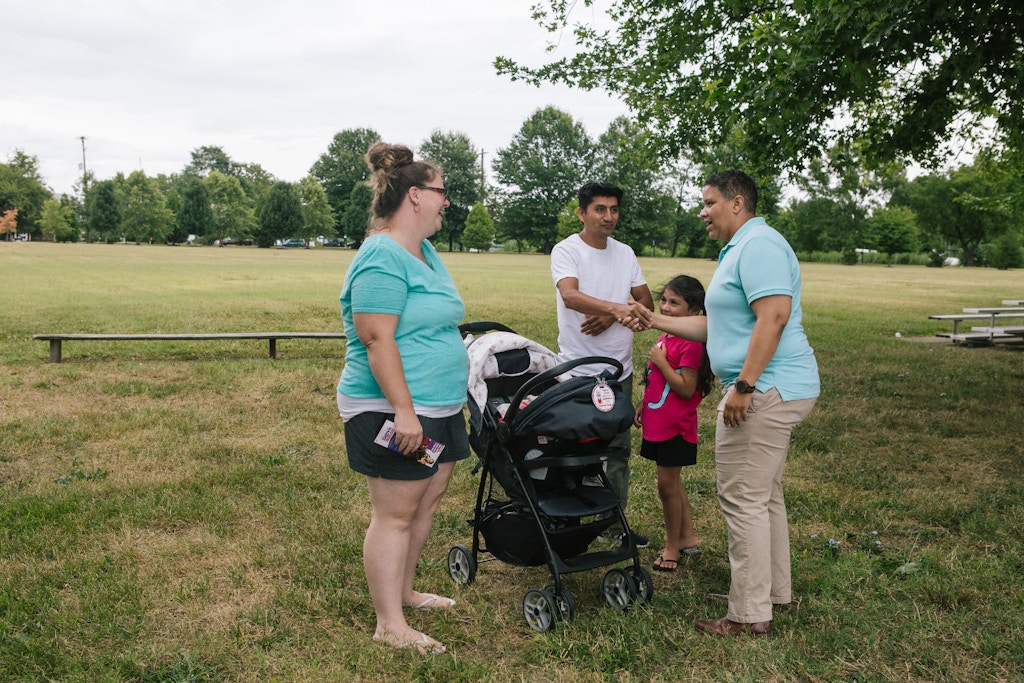 Kerri Evelyn Harris, Democratic candidate for the United States Senate from Delaware, stops to speak with residents Jessica and Oscar Sandoval with their daughter, Sophia, while walking in a parade celebrating Delaware City Day in Delaware City, Delaware on Saturday, July 21, 2018. Harris, a former community organizer and Air Force veteran, is campaigning on issues such as Medicare-For-All, environmental justice, higher minimum wage, expanding LGBTQ rights, and pre-K for all.(Michelle Gustafson for The Intercept)