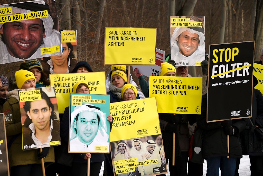 Members of Human rights NGO Amnesty International hold giant portraits of jailed Saudi blogger Raif Badawi and Saudi rights activist and lawyer Waleed Abu Alkhair as they demonstrate in front of the Embassy of Saudi Arabia in Berlin, on January 8, 2016 to ask for their release. Badawi was sentenced to 10 years in prison and 1,000 lashes for insulting Islam.  / AFP / TOBIAS SCHWARZ        (Photo credit should read TOBIAS SCHWARZ/AFP/Getty Images)