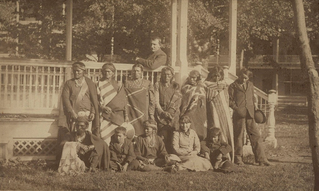 O fundador de Carlisle, Richard Henry Pratt, sentado ao centro do coreto, com um grupo de alunos Navajo recém-chegados à escola em 21 de outubro de 1882.