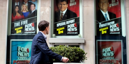 A pedestrian walks past the News Corp. headquarters building in New York displaying posters featuring Fox News Channel personalities including Bill O'Reilly, right, on Wednesday, April 19, 2017. O'Reilly has lost his job at Fox News Channel following reports that five women had been paid millions of dollars to keep quiet about harassment allegations. 21st Century Fox issued a statement Wednesday that 