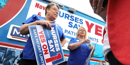 SOMERVILLE, MA - AUGUST 21: Karen Coughlin, left, and Donna Kelly-Williams, president of the Massachusetts Nurses Association, chat following a nurses rally near Partners HealthCare in Somerville, MA on Aug. 21, 2018. The MNA backs ballot initiative #1, that mandates minimum levels of nurse staffing statewide. (Photo by Pat Greenhouse/The Boston Globe via Getty Images)