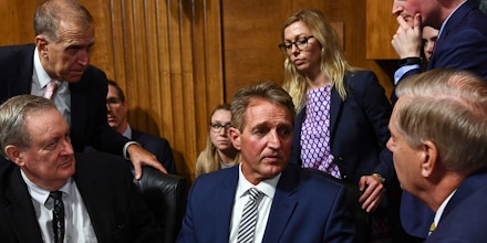 Senate Judiciary Committee member Senator Jeff Flake (R-AZ) (C) speaks with colleagues after a hearing on Capitol Hill in Washington, DC on September 28, 2018, on the nomination of Brett M. Kavanaugh to be an associate justice of the Supreme Court of the United States. - Kavanaugh's contentious Supreme Court nomination will be put to an initial vote Friday, the day after a dramatic Senate hearing saw the judge furiously fight back against sexual assault allegations recounted in harrowing detail by his accuser. (Photo by Brendan Smialowski / AFP)        (Photo credit should read BRENDAN SMIALOWSKI/AFP/Getty Images)