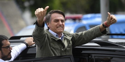 Jair Bolsonaro, far-right lawmaker and presidential candidate for the Social Liberal Party (PSL), gives thumbs up to supporters, during the second round of the presidential elections, in Rio de Janeiro, Brazil on October 28, 2018. - Brazilians will choose their president today during the second round of the national elections between the far-right firebrand Jair Bolsonaro and leftist Fernando Haddad (Photo by MAURO PIMENTEL / AFP)        (Photo credit should read MAURO PIMENTEL/AFP/Getty Images)