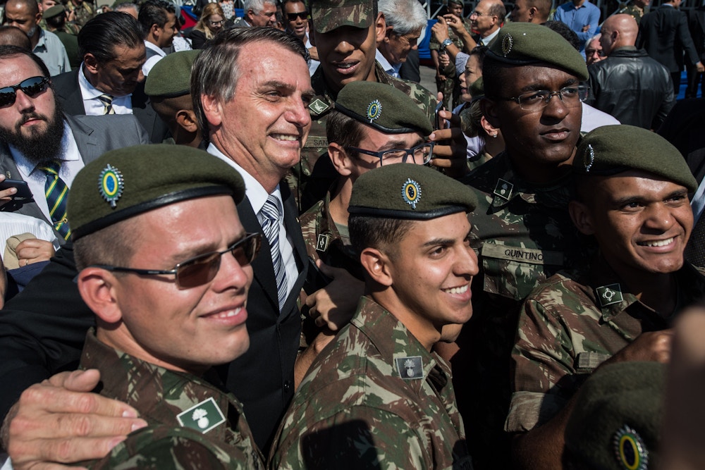 Brazilian congressman and presidential canditate for the next election, Jair Bolsonaro (L), takes pictures with militaries during an military event in Sao Paulo, Brazil on May 3, 2018. (Photo by Nelson ALMEIDA / AFP)        (Photo credit should read NELSON ALMEIDA/AFP/Getty Images)
