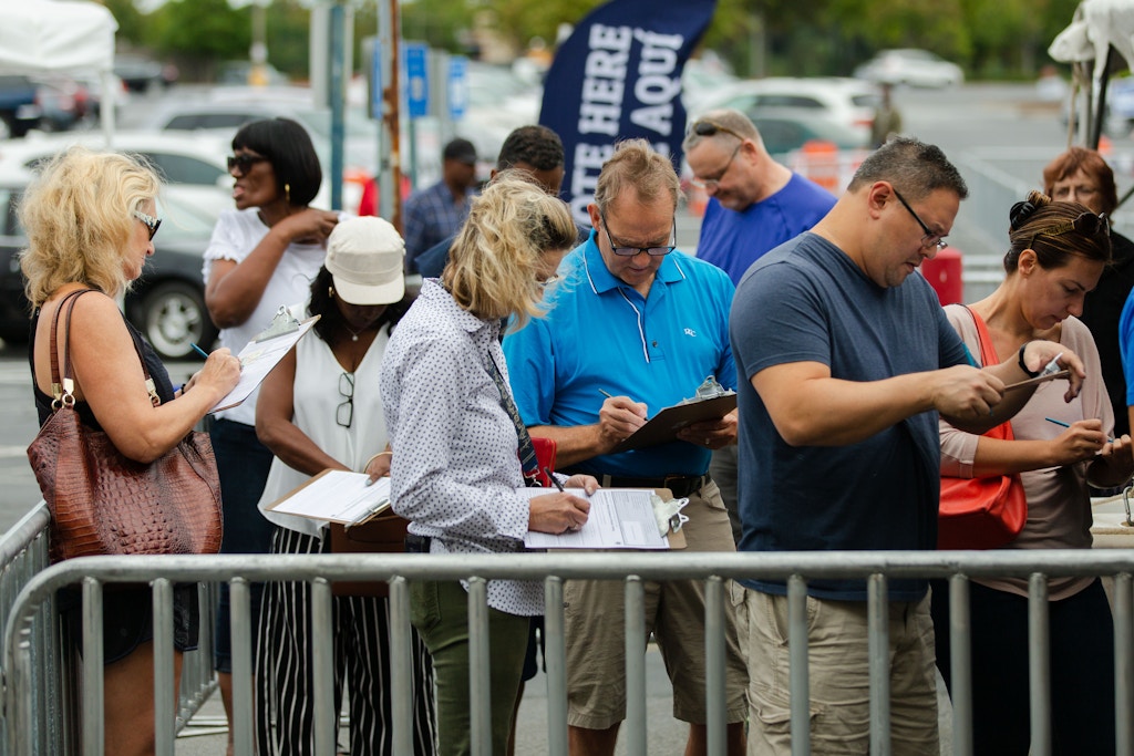 Voters arrive for early voting at the Gwinnett County (Ga.) Voter Registrations and Elections Office in Lawrenceville, Ga., on Wednesday, Oct. 17, 2018. Here, voters fill out paperwork prior to entering the building Photo by Kevin D. Liles for The Intercept