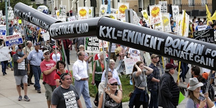 Demonstrators against the Keystone XL pipeline march in Lincoln, Neb., Sunday, Aug. 6, 2017, one day before the Nebraska Public Service Commission begins a five-day public hearing to decide whether to approve the Keystone XL pipeline's route through Nebraska. (AP Photo/Nati Harnik)