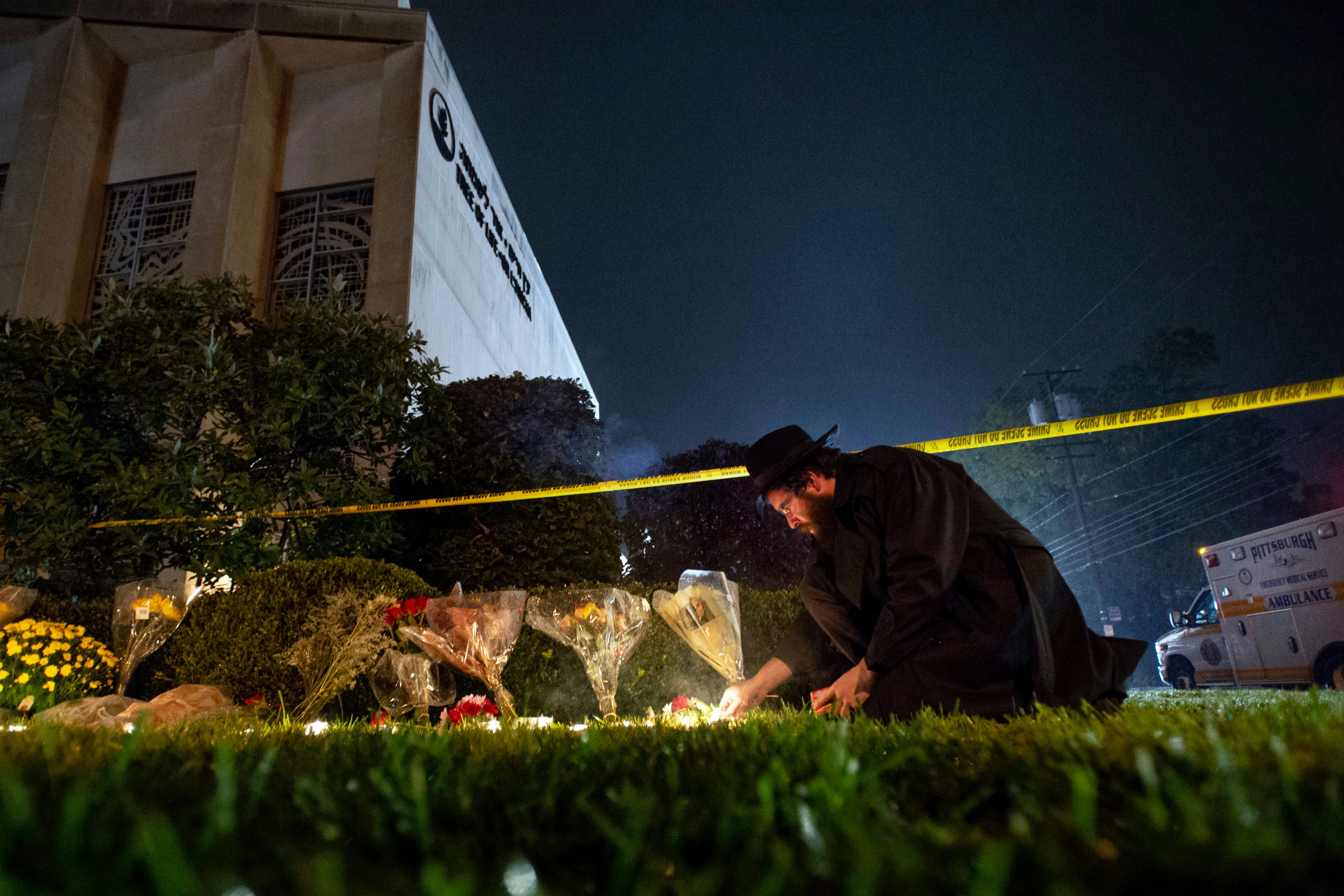 In this Oct. 27, 2018 photo, Rabbi Eli Wilansky lights a candle after a mass shooting at Tree of Life  Synagogue in Pittsburgh's Squirrel Hill neighborhood. Robert Bowers, the suspect in Saturday's mass shooting, expressed hatred of Jews during the rampage and told officers afterward that Jews were committing genocide and he wanted them all to die, according to charging documents made public Sunday. (Steph Chambers/Pittsburgh Post-Gazette via AP)