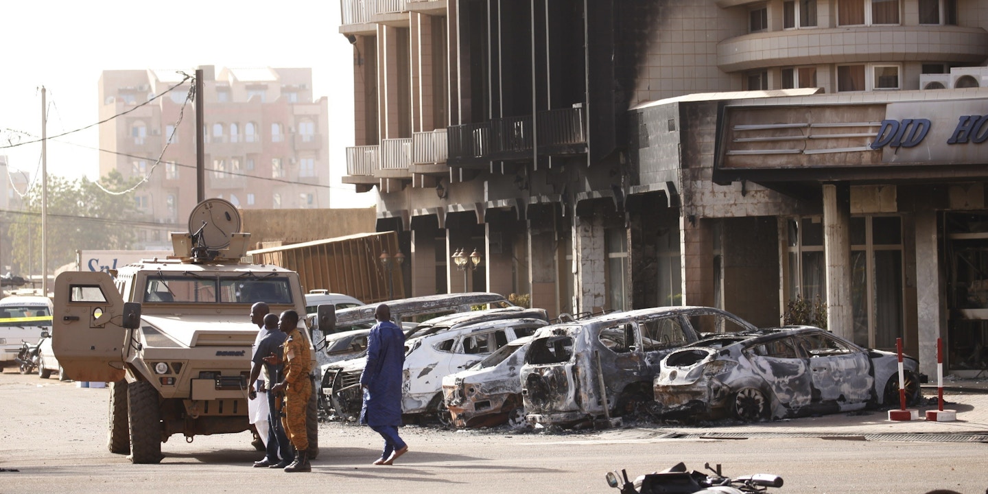 Security forces stand in front of the burned exterior of the Splendid Hotel after an Al Qaeda attack that killed 30 people there and in a restaurant across the street in Ouagadougou, Burkina Faso, January 16, 2016. Joe Penney
