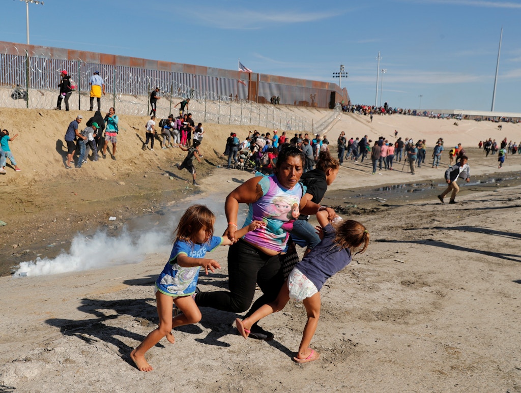 Maria Lila Meza Castro (C), a 39-year-old migrant woman from Honduras, part of a caravan of thousands from Central America trying to reach the United States, runs away from tear gas with her five-year-old twin daughters Saira Nalleli Mejia Meza (L) and Cheili Nalleli Mejia Meza (R) in front of the border wall between the U.S. and Mexico, in Tijuana, Mexico November 25, 2018. REUTERS/Kim Kyung-Hoon     TPX IMAGES OF THE DAY - RC1786AEC760