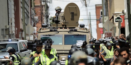 CHARLOTTESVILLE, VA - AUGUST 12:  A Virginia State Police officer in riot gear keeps watch from the top of an armored vehicle after car plowed through a crowd of counter-demonstrators marching through the downtown shopping district August 12, 2017 in Charlottesville, Virginia. The care plowed through the crowed following the shutdown of the Unite the Right rally by police after white nationalists, neo-Nazis and members of the 