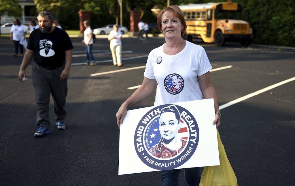 Billie Winner-Davis, mother of Reality Winner, carries a sign in support of her daughter outside the Lincoln County Law Enforcement Center in Lincolnton, Ga., Sunday evening June 3, 2018. Winner-Davis and other supporters gathered outside the jail a year after Reality Winner's arrest. Winner worked for the national security contractor Pluribus International at Fort Gordon in Georgia when she was charged last June with mailing a classified U.S. report to an unidentified news organization. (Michael Holahan/The Augusta Chronicle via AP)