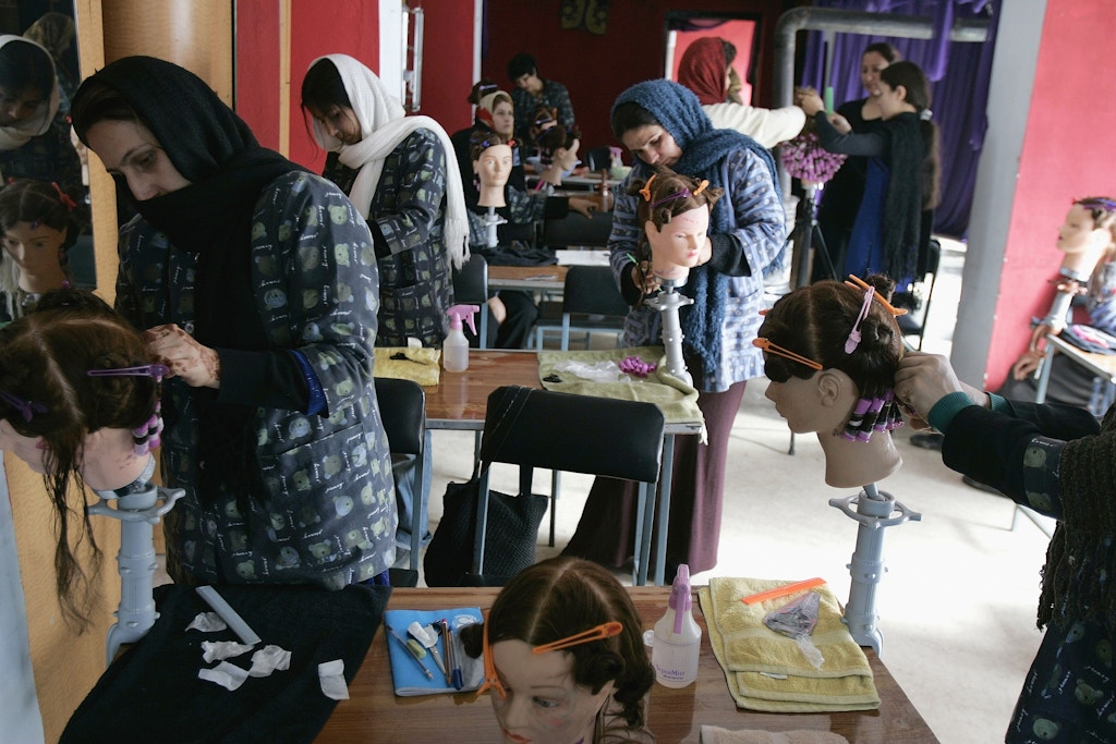 KABUL, AFGHANISTAN - FEBRUARY 13:  Afghan women practice on mannequin heads at Debbie Rodriguez's Oasis Beauty School February 13, 2005 in Kabul, Afghanistan. Rodriguez, 44, operates the school offering three-month courses to Afghan women. The school has graduated over 100 women since 2003. Rodriguez brings students to her commercial salon to observe professional Afghan beauticians perform on western female clients. The school and salon are partially supported by Clairol and Vogue Magazine, who supply funds for rent, cosmetics and furniture, and Paul Mitchell and Redken products. The U.S. Embassy through the U.S. Agency for International Development (AID) assists the operation with funding for renovations of the school, beauty kits for students, head mannequins to practice on and funding for food and kitchen staff. Western beauty standards are kept by Rodriguez, whose mother, son and ex-husband also are beauticians in the U.S. The Afghan women are required to have permission from their families to work with foreigners and to cut foreign men's hair, which not all are permitted to cut. They will earn four to ten times what their husbands bring home for salaries once they start their own beauty salons. Debbie Rodriguez is from Holland, Michigan and has an Afghan husband. The overhead for the school and salon is nearly $200,000 per year.  (Photo by Robert Nickelsberg/Getty Images)