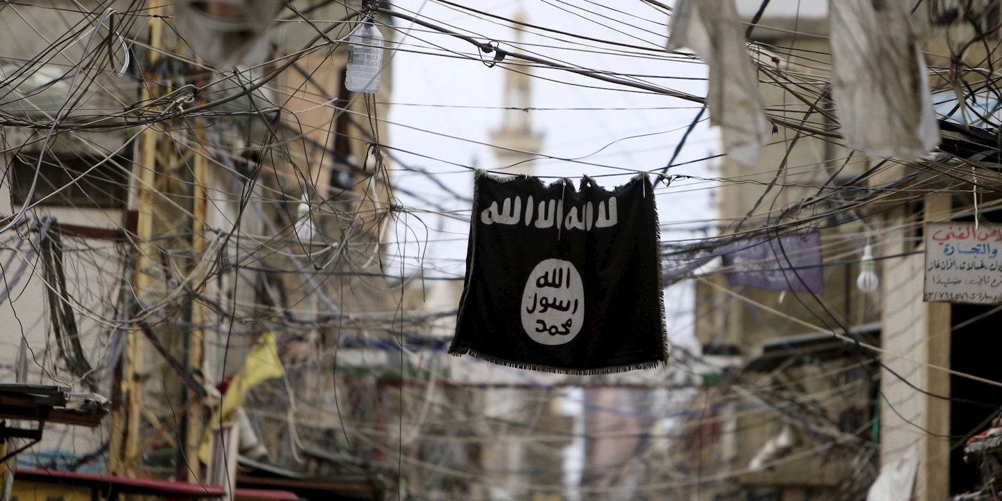 An Islamic State flag hangs amid electric wires over a street in Ain al-Hilweh Palestinian refugee camp, near the port-city of Sidon, southern Lebanon January 19, 2016. REUTERS/Ali Hashisho - GF20000099887