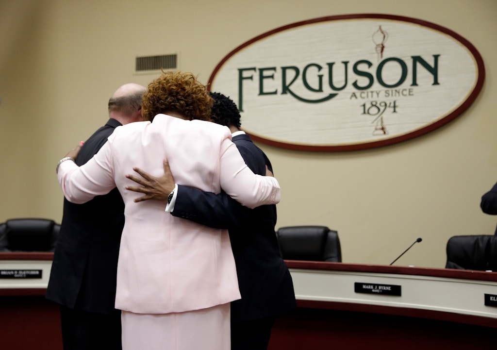 Three newly elected members of the Ferguson City Council, from left, Brian Fletcher, Ella Jones and Wesley Bell embrace after being sworn in during a monthly meeting of the council Tuesday, April 21, 2015, in Ferguson, Mo. With the election, half of the six-member city council in Ferguson, a town where two-thirds of the 21,000 residents are black, will now be African-American. (AP Photo/Jeff Roberson)