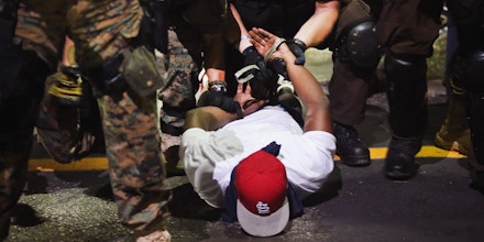 FERGUSON, MO - AUGUST 19:  Police arrest a demonstrator protesting the killing of teenager Michael Brown on August 19, 2014 in Ferguson, Missouri. Brown was shot and killed by a Ferguson police officer on August 9. Despite the Brown family's continued call for peaceful demonstrations, violent protests have erupted nearly every night in Ferguson since his death.  (Photo by Scott Olson/Getty Images)