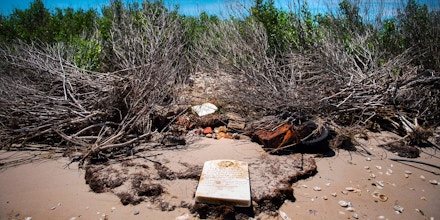 A grave stone rests on the beach where a cemetery once stood but has been washed away due to erosion in an area called Canaan in Tangier, Virginia, May 16, 2017, where climate change and rising sea levels threaten the inhabitants of the slowly sinking island.Now measuring 1.2 square miles, Tangier Island has lost two-thirds of its landmass since 1850. If nothing is done to stop the erosion, it may disappear completely in the next 40 years. / AFP PHOTO / JIM WATSON (Photo credit should read JIM WATSON/AFP/Getty Images)