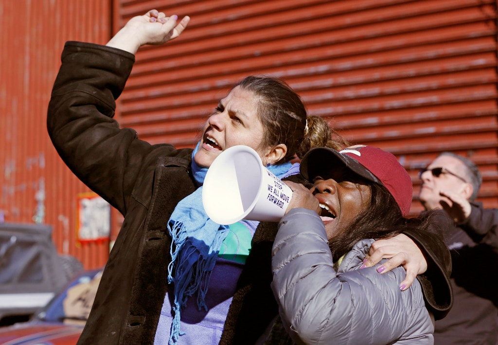 Veronica Matus, 42, an activist from Queens, left, embraces Catana Yehudah, 50, of the Bronx, as Yehuda speaks into the microphone  Sunday, Feb. 3, 2019, in New York, at prisoners listening from inside their cells at the Metropolitan Detention Center, a federal facility of all security levels, where prisoners have been without heat, hot water, electricity and proper sanitation due to an electrical failure since earlier in the week. Yehuda's brother Jason Smith, 40, is serving an 18-month sentence in the prison for gun possession. (AP Photo/Kathy Willens)