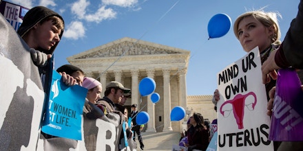 WASHINGTON, DC - MARCH 2:  Pro-choice advocates (right) and anti-abortion advocates (left) rally outside of the Supreme Court, March 2, 2016 in Washington, DC.  On Wednesday morning, the Supreme Court will hear oral arguments in the Whole Woman's Health v. Hellerstedt case, where the justices will consider a Texas law requiring that clinic doctors have admitting privileges at local hospitals and that clinics upgrade their facilities to standards similar to hospitals. (Drew Angerer/Getty Images)