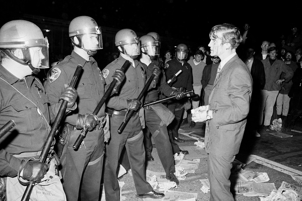 (Original Caption) 5/22/1968-San Francisco, CA- Attorney Terence Hallinan, his face bloody from a gash in his head, confronts the police officer he claims laid his head open while he was trying to help a girl to safety, away from the police. The incident took place after police arrested some 27 demonstrators who were conducting a sit-in in the Administration Building at San Francisco State College late 5/21.