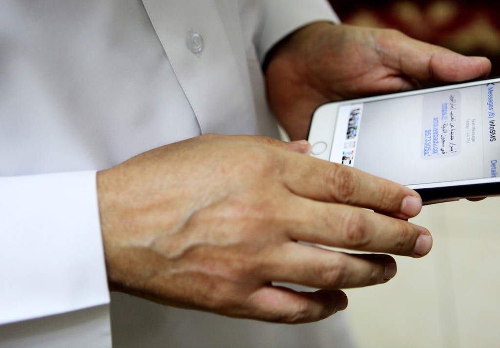 Human rights activist Ahmed Mansoor shows Associated Press journalists a screenshot of a spoof text message he received in Ajman, United Arab Emirates, on Thursday, Aug. 25, 2016. Mansoor was recently targeted by spyware that can hack into Apple's iPhone handset. The company said Thursday it has updated its security. The text message reads: "New secrets on the torture of Emirati citizens in jail." (AP Photo/Jon Gambrell)