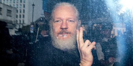 LONDON, ENGLAND - APRIL 11: Julian Assange gestures to the media from a police vehicle on his arrival at Westminster Magistrates court on April 11, 2019 in London, England.  After weeks of speculation Wikileaks founder Julian Assange was arrested by Scotland Yard Police Officers inside the Ecuadorian Embassy in Central London this morning. Ecuador's President, Lenin Moreno, withdrew Assange's Asylum after seven years citing repeated violations to international conventions. (Photo by Jack Taylor/Getty Images)