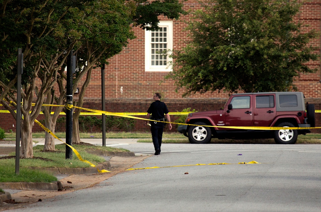 A police officer walks at the scene where eleven people were killed during a mass shooting at the Virginia Beach city public works building, Friday, May 31, 2019 in Virginia Beach, Va. A longtime, disgruntled city employee opened fire at a municipal building in Virginia Beach on Friday, killing 11 people before police fatally shot him, authorities said.  Six other people were wounded in the shooting, including a police officer whose bulletproof vest saved his life, said Virginia Beach Police Chief James Cervera. (L. Todd Spencer/The Virginian-Pilot via AP)