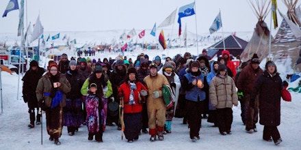 FILE - In this Thursday, Dec. 1, 2016, file photo, Beatrice Menase Kwe Jackson, center, walks with Daniel Emory, both of the Ojibwe Native American tribe as they lead a procession to the Cannonball river for a traditional water ceremony at the Oceti Sakowin camp where people have gathered to protest the Dakota Access oil pipeline in Cannon Ball, N.D. Some Native Americans worry the transition to a Donald Trump administration signals an end to eight years of sweeping Indian Country policy reforms. Trump rarely acknowledged Native Americans during his campaign. And he hasn't publicly outlined since the election how he would improve or manage the United States' longstanding relationships with tribes. (AP Photo/David Goldman, File)