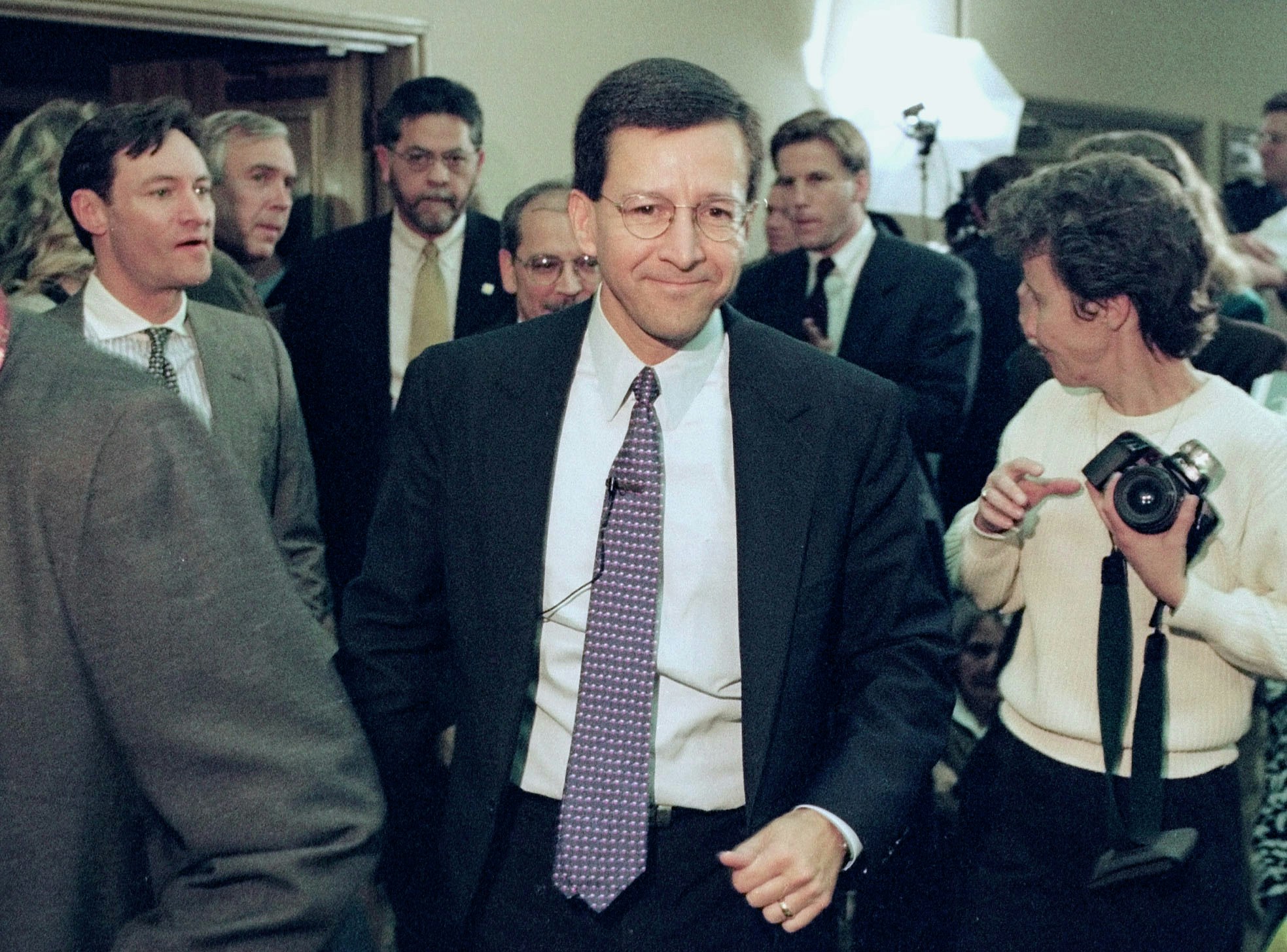 ** FILE ** Dan Morales, center, then Texas Attorney General, shown in this file photo from Jan. 16, 1998, moves through a crowd before his news conference to announce the award of $15.32 billion to the state from the tobacco industry. Former Texas Attorney General Dan Morales and a onetime law associate were indicted Thursday, March 6, 2003, on federal charges of trying to fraudulently obtain hundreds of millions of dollars in attorney fees from a state settlement with tobacco companies.  Both Morales and Marc Murr, a former associate and personal friend, were expected to turn themselves in Friday, authorities said. (AP Photo/Harry Cabluck, File)