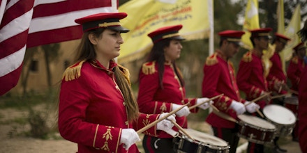 A military band performs ahead of a ceremony at al-Omar Oil Field marking the U.S.-backed Syrian Democratic Forces (SDF) capture of Baghouz, Syria, after months of fighting to oust Islamic State militants Saturday, March 23, 2019.  The elimination of the last Islamic State stronghold in Baghouz brings to a close a grueling final battle that stretched across several weeks and saw thousands of people flee the territory and surrender in desperation, and hundreds killed. (AP Photo/Maya Alleruzzo)