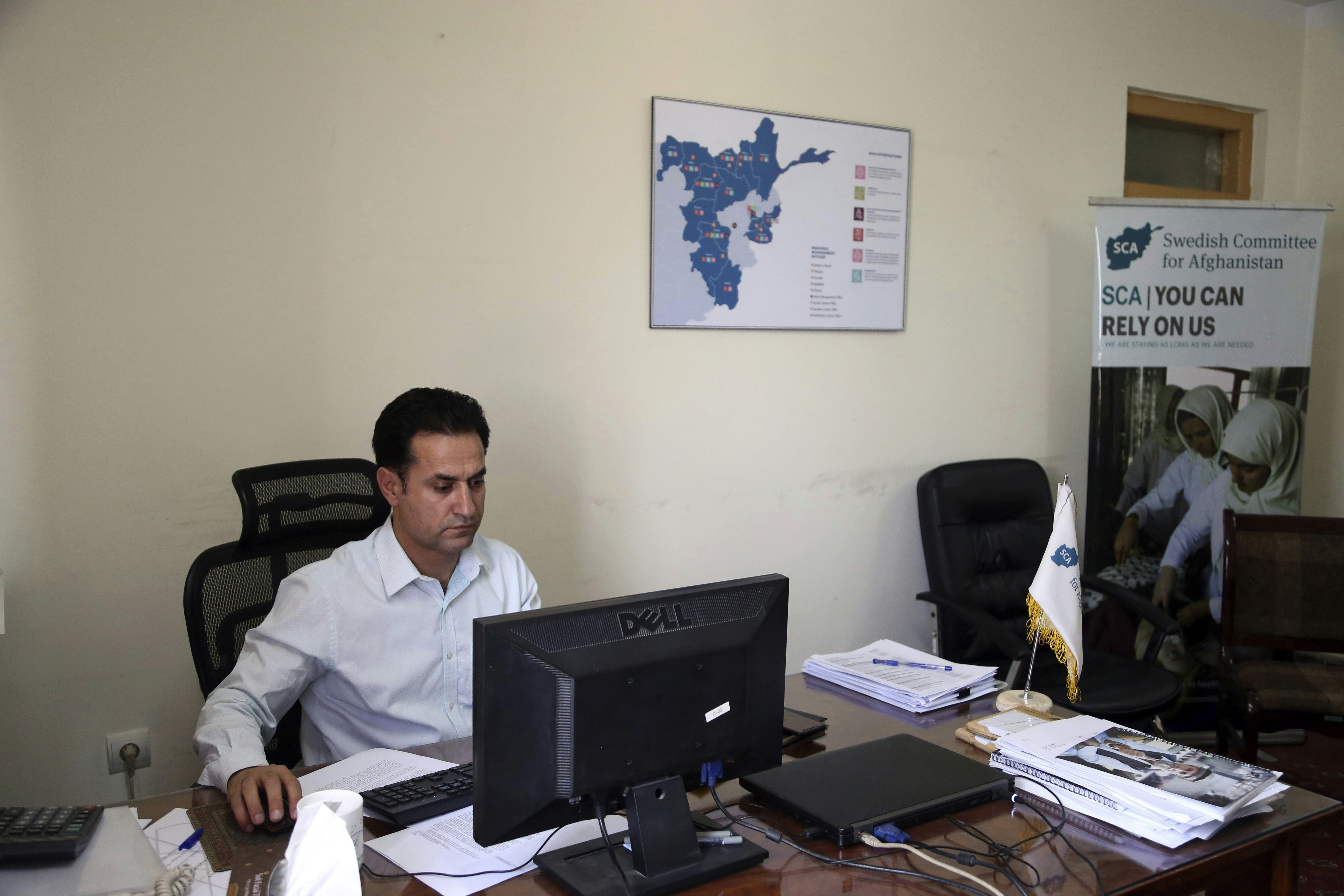 Ahmad Khalid Fahim, program director for the Swedish group, works at his desk, during an interview with the Associated Press in Kabul, Afghanistan, Wednesday, July 17, 2019. A Swedish non-governmental organization in Afghanistan says the Taliban have forced the closure of 42 health facilities run by the non-profit group in eastern Maidan Wardan province. (AP Photo/Rahmat Gul)