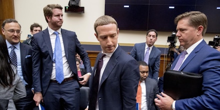 Facebook CEO Mark Zuckerberg, center, accompanied by Facebook vice president for U.S. public policy, Kevin Martin, right, takes a break from testimony before a House Financial Services Committee hearing on Capitol Hill in Washington, Wednesday, Oct. 23, 2019, on Facebook's impact on the financial services and housing sectors. (AP Photo/Andrew Harnik)