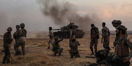 Turkish soldiers and Turkey-backed Syrian fighters gather on the northern outskirts of the Syrian city of Manbij near the Turkish border on October 14, 2019, as Turkey and its allies continue their assault on Kurdish-held border towns in northeastern Syria. - Turkey wants to create a roughly 30-kilometre (20-mile) buffer zone along its border to keep Kurdish forces at bay and also to send back some of the 3.6 million Syrian refugees it hosts. (Photo by Zein Al RIFAI / AFP) (Photo by ZEIN AL RIFAI/AFP via Getty Images)