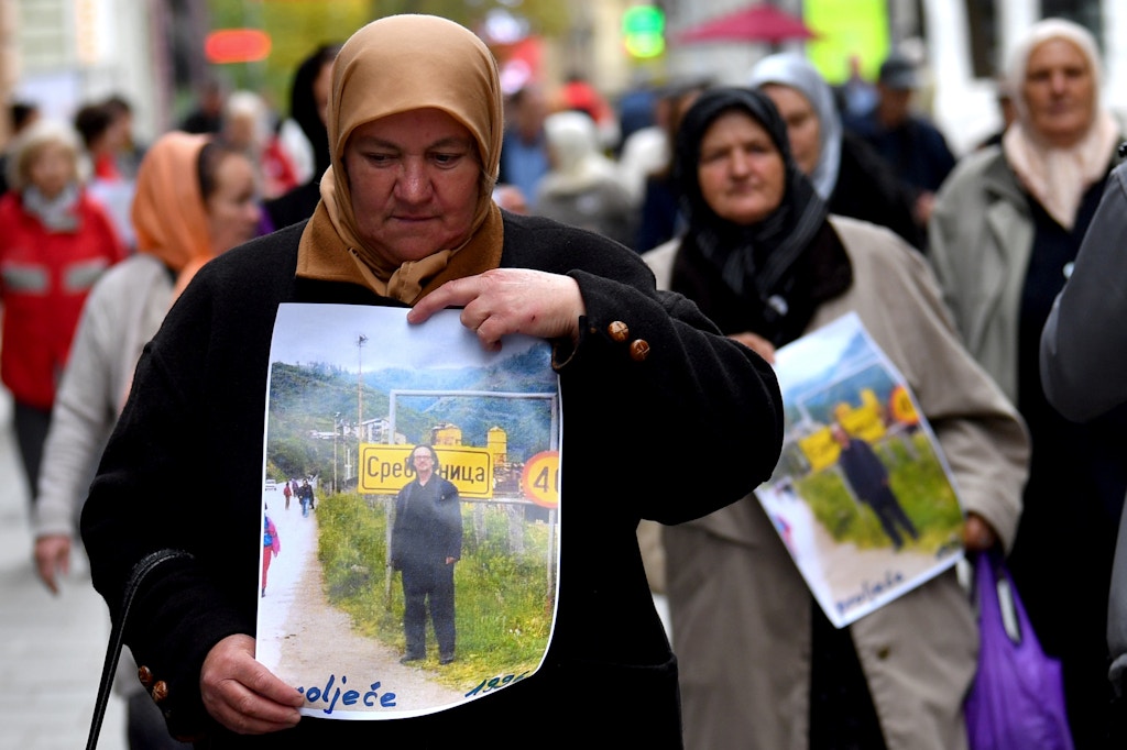Women from Srebrenica and Bosnian members of associations of survivors of the war in Bosnia (1992 - 1995), hold placards depicting Austrian writter Peter Handke as they take part in a demonstration in front of the Swedish Embassy in Sarajevo, on November 5, 2019, to protest against Nobel literature prize laureate Handke, whom they accuse of being a Serb apologist during the 1990s wars. - Demonstrators hold photos of the writer while he was on a personal visit to their hometown of Srebrenica, where some 8,000 Bosnian Muslim men and boys were slaughtered by Bosnian Serb forces in July 1995. The photo shows the novelist standing in front of a sign at the entrance of the town allegedly in 1996, according to the women protesting. The Swedish academy's pick last month trigged outrage in the Balkans and beyond because of Handke's admiration for late Serbian strongman Slobodan Milosevic. (Photo by ELVIS BARUKCIC / AFP) (Photo by ELVIS BARUKCIC/AFP via Getty Images)