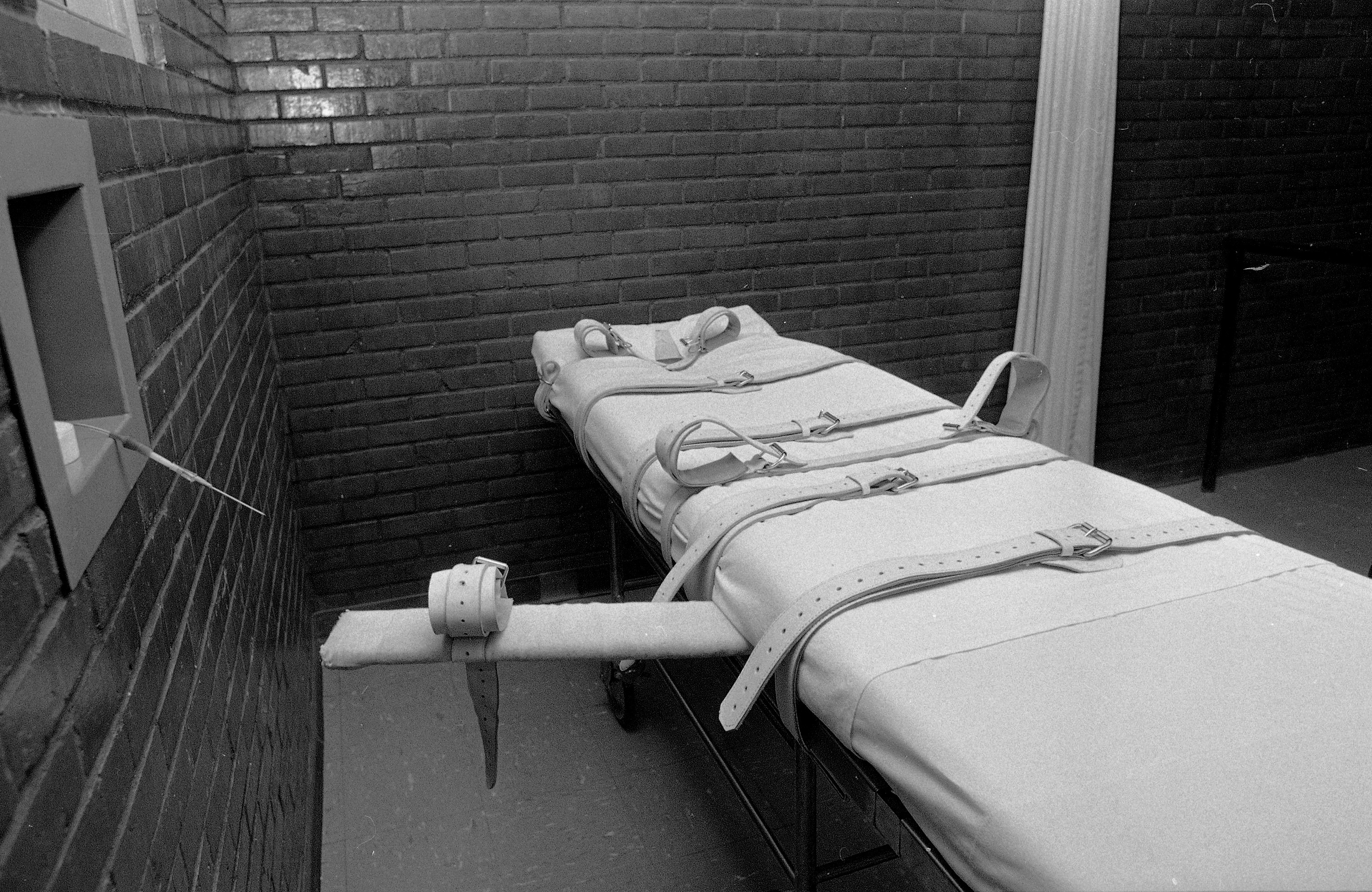 A hospital-type gurney is used for execution by lethal injection at the Texas Department of Corrections in Huntsville, Tex., Dec. 6, 1982.  Restraints rest on top of the gurney and an intravenous needle is visible at the observation window at left.  (AP Photo/Ed Kolenovsky)
