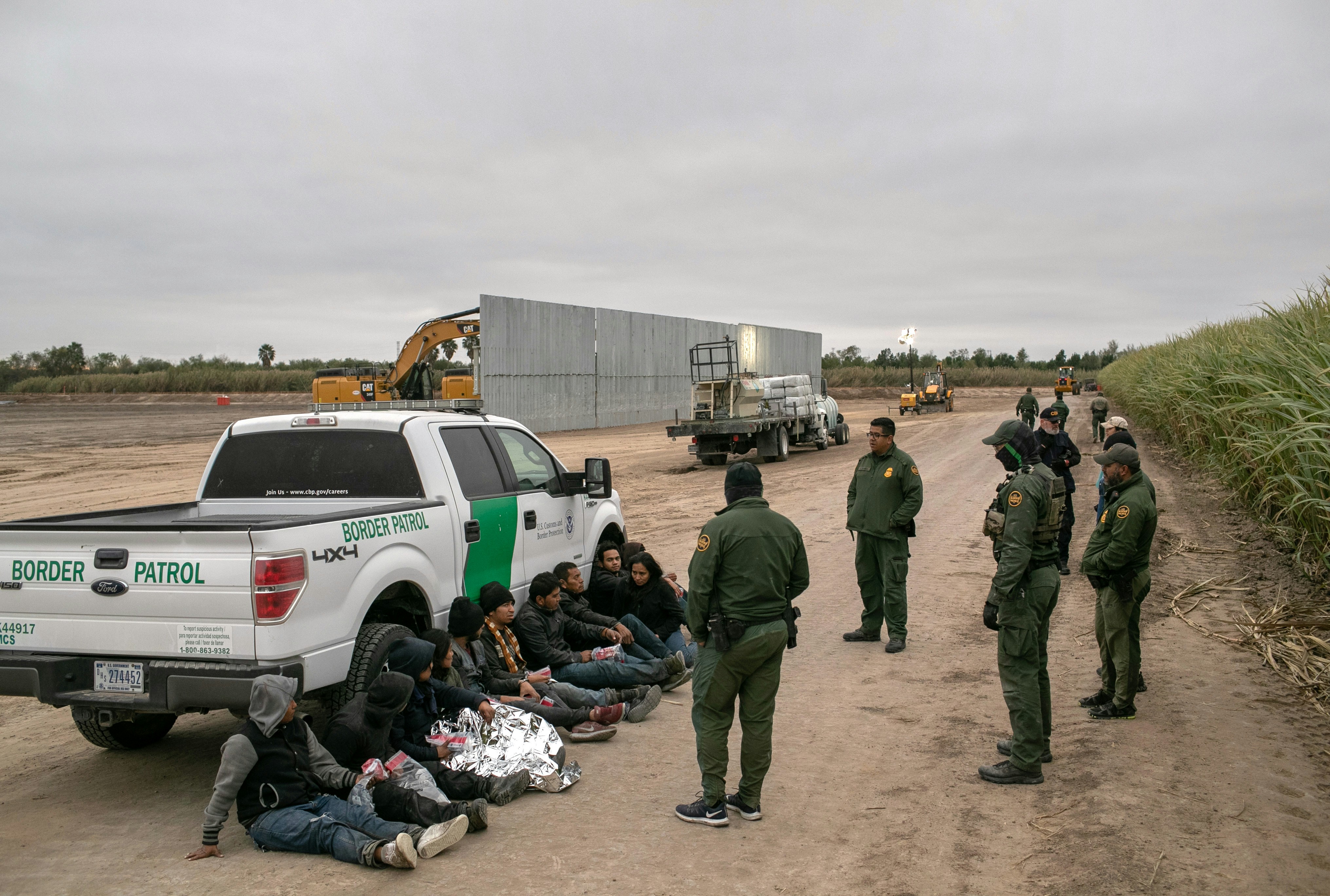 MISSION, TEXAS - DECEMBER 11: U.S. Border Patrol agents detain undocumented immigrants caught near a section of privately-built border wall under construction on December 11, 2019 near Mission, Texas. The hardline immigration group We Build The Wall is funding construction of the wall on private land along the Rio Grande, which forms the border with Mexico. The group, led by former Trump strategist Stephen Bannon claims to have raised tens of millions of dollars in a GoFundMe drive to build sections of wall along stretches of the U.S. southwest border with Mexico. (Photo by John Moore/Getty Images)