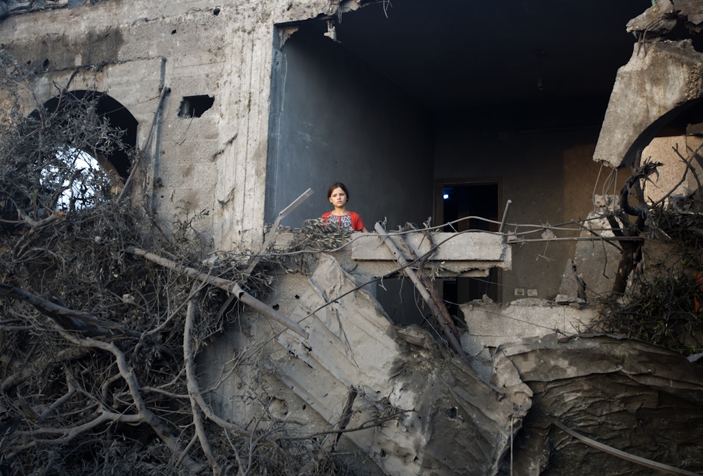 A Palestinian girl stands in a destroyed building following an Israeli military strike in  Gaza City on July 08, 2014 . The Israeli air force launched dozens of raids on the Gaza Strip overnight after massive rocket fire from the enclave pounded southern Israel, leaving 17 people injured, sources said. AFP PHOTO / MAHMUD HAMS        (Photo credit should read MAHMUD HAMS/AFP via Getty Images)