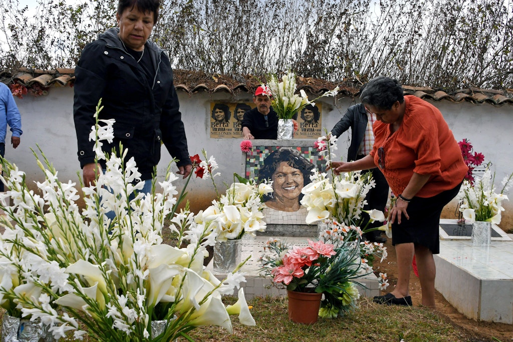 Relatives and friends place flowers at indigenous environmentalist Berta Caceres grave in La Esperanza, Honduras, on March 3, 2018. Relatives and indigenous people demanded justice to the intellectual authors of the murder of the prestigious environmentalist Berta Caceres, executed two years ago for opposing the construction of a hydroelectric dam on a river. / AFP PHOTO / Orlando SIERRA (Photo credit should read ORLANDO SIERRA/AFP via Getty Images)