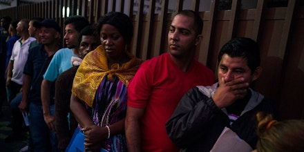 Migrants wait in line outside the Mexican Commission for Migrant Assistance office to get the documents needed that allows them to stay in Mexico, in Tapachula, Thursday, June 20, 2019. The flow of migrants into southern Mexico has seemed to slow in recent days as more soldiers, marines, federal police, many as part of Mexico's newly formed National Guard, deploy to the border under a tougher new policy adopted at a time of increased pressure from the Trump administration.  (AP Photo/Oliver de Ros)